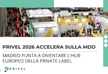 Aerial view of a crowded trade show with multiple booths and attendees, banners reading Italian branding visible in the background.