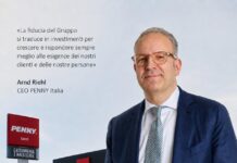 CEO Arnd Riehl of PENNY Italia stands in a navy suit beside a PENNY store; Italian quote about trust is shown to the left.