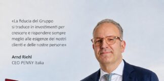 CEO Arnd Riehl of PENNY Italia stands in a navy suit beside a PENNY store; Italian quote about trust is shown to the left.