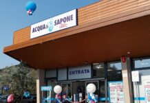 Storefront of Acqua e Sapone with a blue and white sign, balloon decorations, and an entrance labeled Entrata for a festive opening.