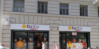 Storefront of a Today CONAD supermarket with large signs and window decals showing fruit and food icons on beige building façade