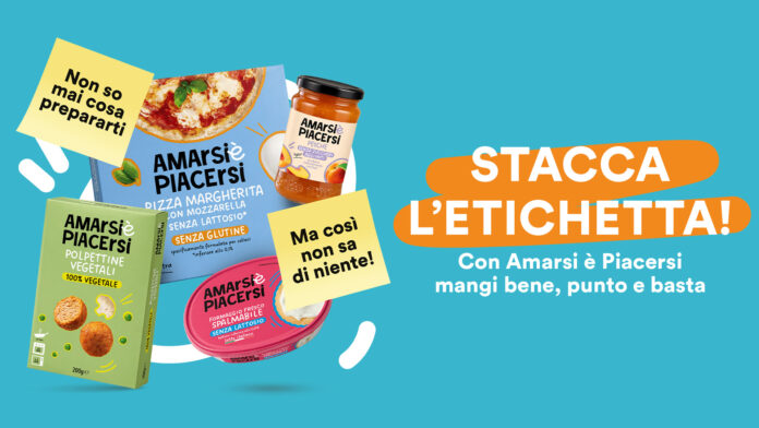 Colorful Italian ad for Amarsi è Piacersi; boxed pasta, jar sauce and snacks on a teal background with bold orange banner text STACCA L'ETICHETTA!