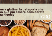 Senza glutine: la categoria che non può più essere considerata una nicchia Hero banner with Italian headline on gluten-free being no longer a niche; GDQ data logo on the right, over background of bread, pasta and grains.