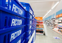 Action raggiunge 247 negozi in Italia con gli store di Mercogliano e Cerignola Blue plastic crates labeled 'ACTION' stacked along a supermarket shelf/aisle.