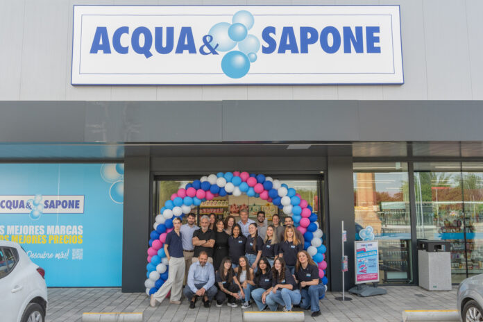 A&S tomelloso AP-28 (1) Group of employees posing under a blue-pink balloon arch in front of the ACQUA & SAPONE store sign during a grand opening celebration.
