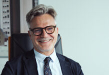 Dit, bilancio 2025 positivo: ricavi a 19,1 milioni e focus sulla marca privata Smiling mature man with gray hair and glasses, wearing a dark suit and tie in an office setting.
