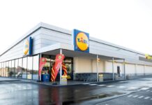 Lidl apre a Terlizzi e porta a 16 gli store tra Bari e provincia Lidl supermarket exterior with the brand logo, entrance framed by red and yellow balloons and promotional banners, shopping carts lined up outside.