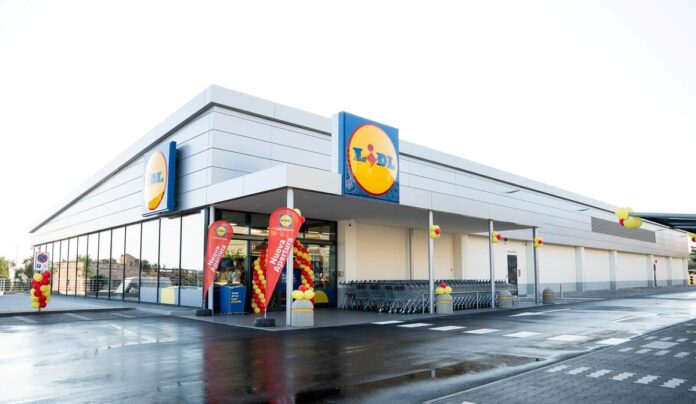 CS Lidl - Terlizzi 02 (1) Lidl supermarket exterior with the brand logo, entrance framed by red and yellow balloons and promotional banners, shopping carts lined up outside.