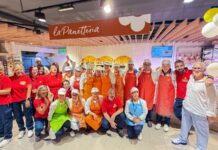 Conad Adriatico rinnova il punto vendita di Sulmona tra freschi, territorio e nuovi servizi Group of bakery employees in red shirts and aprons posing together inside a La Panetteria shop.