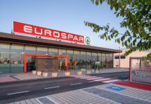 EuroSpar supermarket exterior with a large red sign, glass entrance and shopping carts outside on a sunny day.