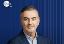Francesco Avanzini, Presidente GS1 Italy, portrait in a navy suit against a blue striped backdrop with the GS1 Italy logo