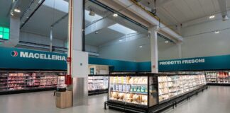 Altasfera debutta in Abruzzo con nuovo il Cash & Carry di San Salvo Interior of a modern supermarket with long refrigerated meat and dairy displays; teal signs read Macelleria and Prodotti Freschi on the walls.