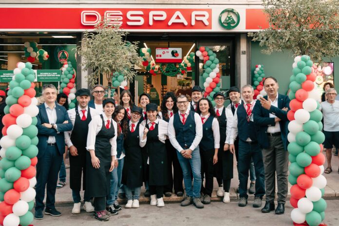 Despar Apertura Andria Group of Spar staff posing outside the store, wearing uniforms, with green, white and red balloon arches for a festive event.