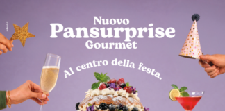 Pansurprise diventa Gourmet: Valle Fiorita alza il livello della gastronomia Promotional image for Nuovo Pansurprise Gourmet featuring a tall layered cake with berries and cream, flanked by champagne glasses and party hats for a festive center-plate celebration theme.