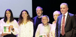 Coop Alleanza 3.0, in Romagna 420 milioni di vendite e 235mila soci attivi Group of six adults on a stage posing for a photo, two women in front hold framed pictures.