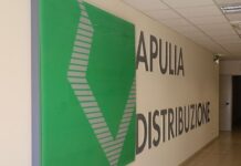 Apulia Distribuzione apre una nuova fase con la famiglia Sgaramella dopo il mandato di Schiraldi Hallway with large 'APULIA DISTRIBUZIONE' sign on the wall and a green decorative panel on the left.
