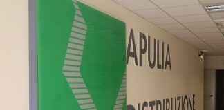 Hallway with large 'APULIA DISTRIBUZIONE' sign on the wall and a green decorative panel on the left.
