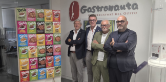Decò Italia, termina il percorso di Mario Gasbarrino: nuova governance per la società Four men in smart-casual attire pose with crossed arms in front of a wall with the 'Gastronauta' logo and a colorful cereal box display on a stand.
