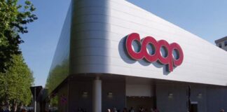 Modern supermarket storefront with large red Coop logo and people entering