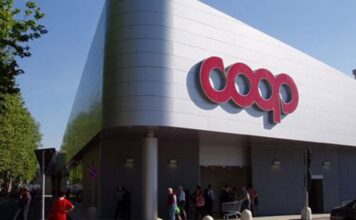Modern supermarket storefront with large red Coop logo and people entering