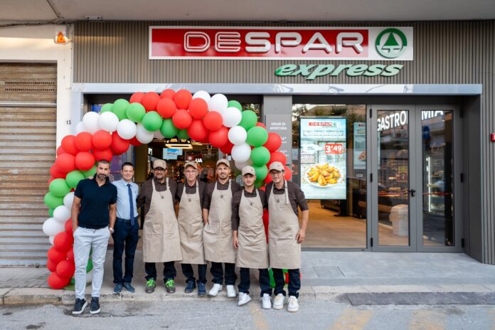 despar express 2026 01 Group of staff in beige aprons posing outside a Despar Express store under a red-green balloon arch.