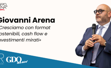 Giovanni Arena: «Cresciamo con format sostenibili, cash flow e investimenti mirati» Giovanni Arena speaks into a microphone on a promotional banner with Gruppo Arena logo and a blue diagonal strip showing PR Italia Edizioni and GDQ News logos.