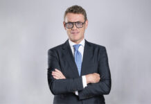 Multicedi chiude il 2025 in crescita e nomina Harald Antley Amministratore Delegato Professional portrait of a man in a dark suit with a blue tie, arms crossed, facing the camera.