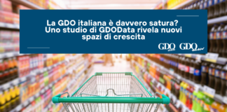 La GDO italiana è davvero satura? Uno studio di GDOData rivela nuovi spazi di crescita Banner text: Italian grocery distribution studied for growth; reads 'La GDO italiana è davvero sat…' over a blurred supermarket with a green shopping cart in the foreground
