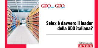 Selex è davvero il leader della GDO italiana? Photo of a supermarket aisle filled with colorful products on both sides, plus a white panel with the headline: "Selex è davvero il leader della GDO italiana?" Patrocinato da arneg on the bottom right.