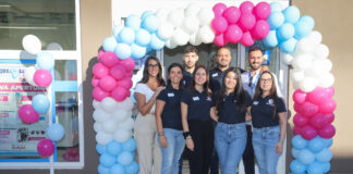 Cesar raggiunge quota 900 negozi con il nuovo Acqua & Sapone di Elmas Nine staff members in navy shirts pose under a colorful balloon arch at the store entrance, smiling for a group photo.