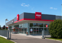 PENNY cambia passo nella Bergamasca con il nuovo punto vendita di Ghisalba Penny Ghislba supermarket exterior with red signage and glass entrance under a clear blue sky.