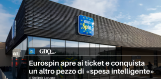 Eurospin apre ai ticket e conquista un altro pezzo di «spesa intelligente» Exterior of EuroSpin supermarket with blue logo sign on a modern building; article headline about smart shopping in Italian.