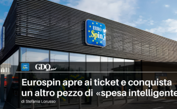 Eurospin apre ai ticket e conquista un altro pezzo di «spesa intelligente» Exterior of EuroSpin supermarket with blue logo sign on a modern building; article headline about smart shopping in Italian.