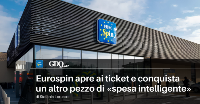 1200x628-ticket-eurospin Exterior of EuroSpin supermarket with blue logo sign on a modern building; article headline about smart shopping in Italian.