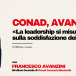 Conad, Avanzini: «La leadership si misura sulla soddisfazione dei clienti» Man in a navy suit on a beige background left of a bold Italian headline about leadership and customer satisfaction, with Conad and GDO News logos on the right.