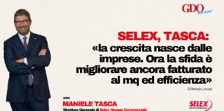 Selex, Tasca: «la crescita nasce dalle imprese. Ora la sfida è migliorare ancora fatturato al mq ed efficienza» Man in a navy suit with arms crossed stands to the left as a bold Italian headline fills the right side of the image, with logos in the corners.