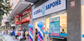 Acqua & Sapone presidia la Spagna centrale con due nuovi punti vendita People line up outside a Cosmopolitan-style shopfront with blue and white balloons decorating the entrance and a large ACQUA& SAPONE sign above the doorway, on a busy street.