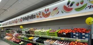 iN’S Mercato cresce in Lombardia con lo store di Villa Cortese Supermarket produce aisle with a colorful fruit banner reading 'Ortofrutta' and crates of tomatoes and other fruit below.