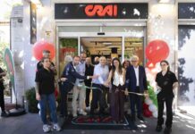 Crai rafforza la prossimità urbana a Roma con il nuovo store all’Aventino Group of people cutting a ribbon at a CRAI storefront opening, surrounded by balloons and onlookers outside the shop.