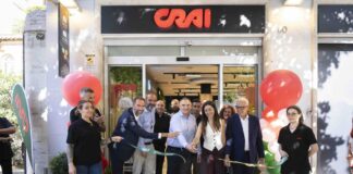 Crai rafforza la prossimità urbana a Roma con il nuovo store all’Aventino Group of people cutting a ribbon at a CRAI storefront opening, surrounded by balloons and onlookers outside the shop.