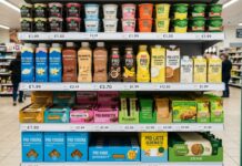 High protein, lo scaffale entra nella fase della selezione Shelves stocked with protein drinks, yogurts, and snacks in a grocery store with visible price tags