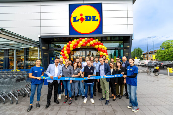 Lidl_Lugo (3) (1) Group of Lidl staff and customers pose in front of the store under a red-yellow balloon arch, holding a blue ribbon reading '1306 Lugo' and '10 Settembre 2026'.