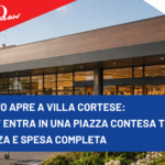 iN’S Mercato apre a Villa Cortese: il discount entra in una piazza contesa tra convenienza e spesa completa Modern supermarket exterior with a bold blue news banner across the front reading: "IN’S mercato apre a Villa Cortese: Il discount entra in una piazza contesa tra convenienza e spesa completa" and sponsor logos in the corners.