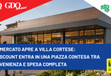 iN’S Mercato apre a Villa Cortese: il discount entra in una piazza contesa tra convenienza e spesa completa Modern supermarket exterior with a bold blue news banner across the front reading: "IN’S mercato apre a Villa Cortese: Il discount entra in una piazza contesa tra convenienza e spesa completa" and sponsor logos in the corners.