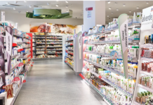 Dm Italia inaugura un nuovo drugstore a Bassano del Grappa Wide, bright cosmetics aisle in a store with shelves stocked of skincare and beauty products on both sides.