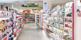 Dm Italia inaugura un nuovo drugstore a Bassano del Grappa Wide, bright cosmetics aisle in a store with shelves stocked of skincare and beauty products on both sides.