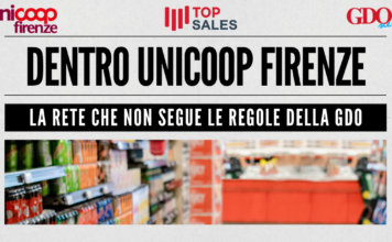Banner announcing Unicoop Firenze with bold headline and subheading about not following GDO rules; shows a blurred supermarket aisle photo and logos top left/right and center-left.